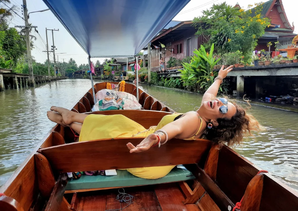 eu no barco com osbraços abertos, feliz e livre, em um barco na Tailândia.
